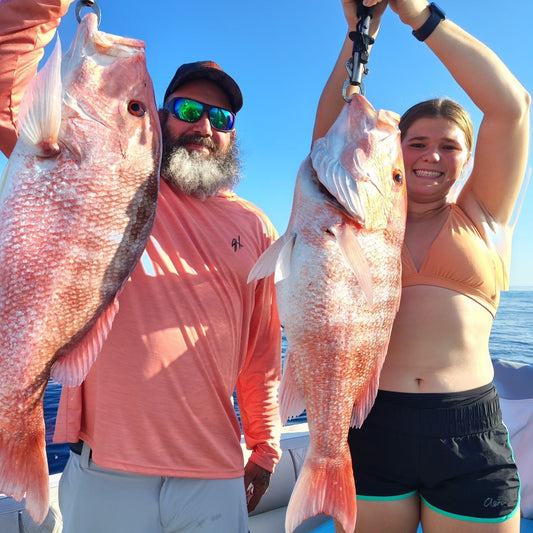 Anglers holding large snapper caught with offshore fishing jigs on a boat