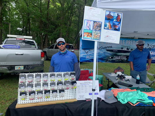 SnappaSlappa saltwater fishing jigs and apparel at outdoor vendor booth with customer testimonials